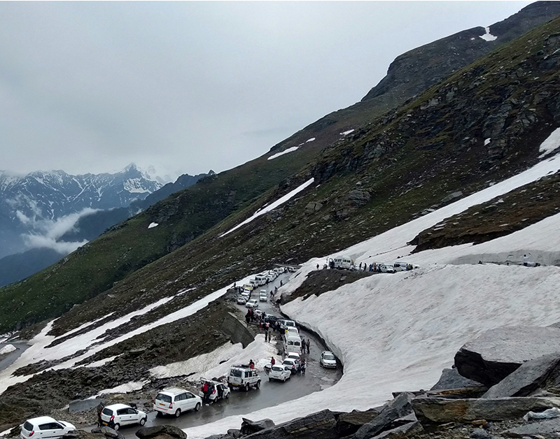 A winding mountain road filled with cars stretching as far as the eye can see.