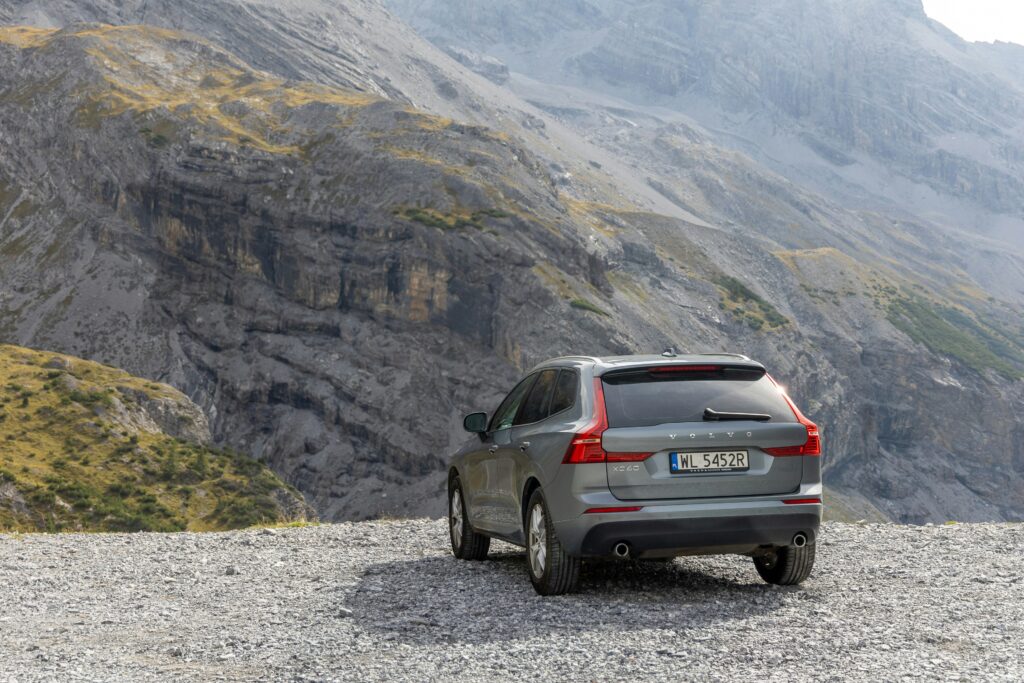 A car parked on a rocky road with mountains in the background.