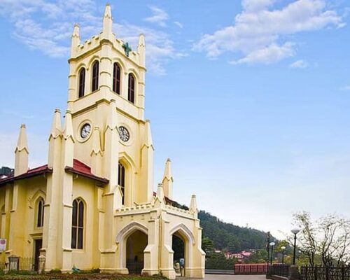 Christ Church Shimla, a historic yellow Anglican church with a tall spire.