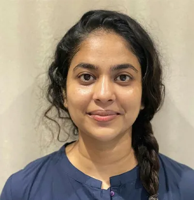 Smiling woman with braids in blue shirt posing for camera