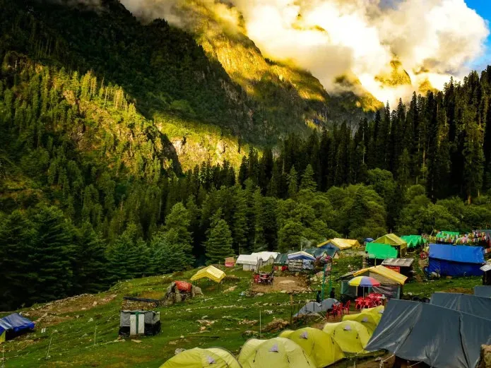 A campsite with colorful tents set up on a grassy hillside